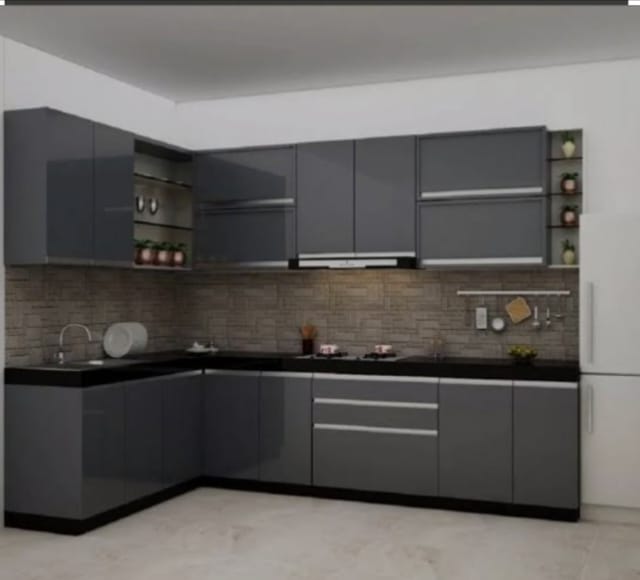 Grey L-shaped modular kitchen with stone backsplash designed by M B Interior in Bikaner